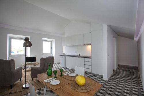 a living room with a table and a kitchen at Place Of Moments Urban-Suites in Ponta Delgada