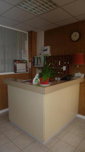 a kitchen with a counter with a clock on the wall at Hotel des Vosges in Paris