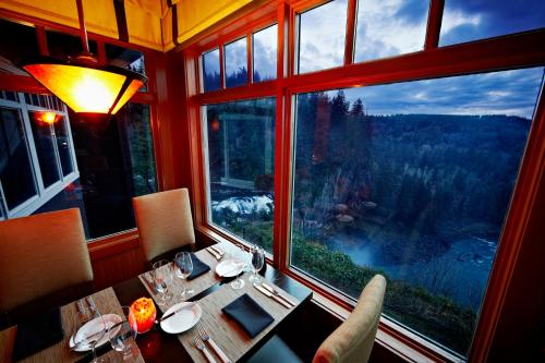 a dining room with a table and a large window at Salish Lodge & Spa in Snoqualmie