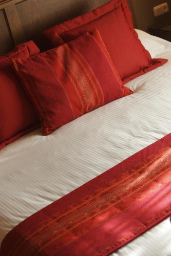 a bed with red pillows on top of it at Gran Hotel Los Abetos in Santiago de Compostela