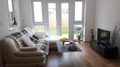 a living room with a couch and a tv at Lavi's house-East Milton Keynes in Milton Keynes