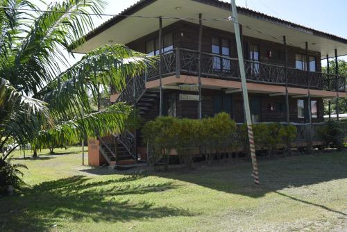 a building with stairs and a palm tree in front of it at Villas Maria Luisa in Uvita