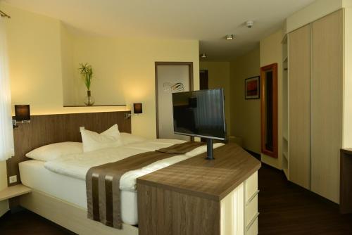 a bedroom with a bed with a flat screen tv at Gasthof Robben in Twist