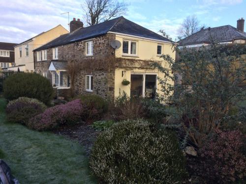 an old stone house in a garden at Priory Cottage Bodmin in Bodmin