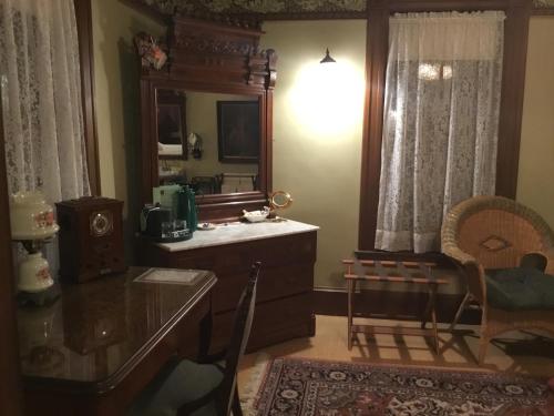 a bathroom with a vanity and a mirror and a table at Allen House Inn in Amherst