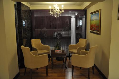 a dining room with chairs and a table and a chandelier at Buyuk Truva Hotel in Canakkale