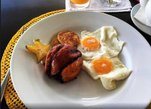 a plate of breakfast food with eggs and biscuits at Gaia Hotel & Reserve- Adults Only in Manuel Antonio