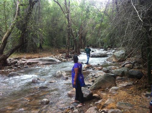 a man and a woman walking across a river at Holiyday in VGF Farm House in Dānishpet