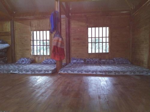 a large room with two beds and two windows at Flower hmong homestay in Bắc Hà