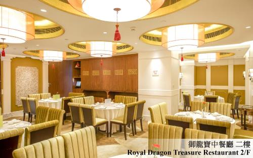 a restaurant with tables and chairs and chandeliers at Royal Dragon Hotel in Macau