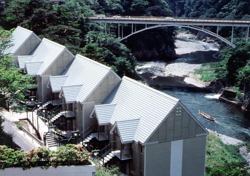 a row of houses on a hill next to a river at Tabist Kinugawa Park Cottage in Nikko
