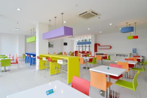 a dining room with colorful tables and chairs at POP! Hotel Airport Jakarta in Tangerang