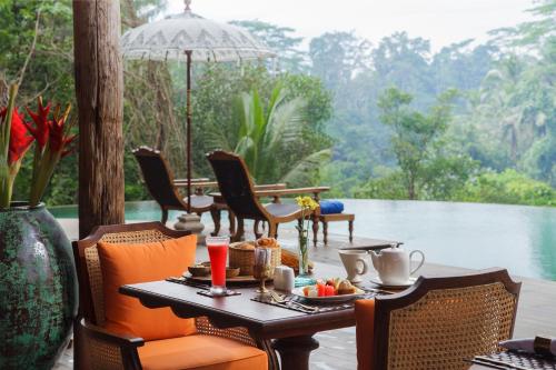a table with food on it with a view of the water at Natya Resort Ubud in Ubud