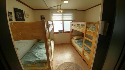 a room with three bunk beds and a window at Dalbit stay Seodaejeon in Daejeon