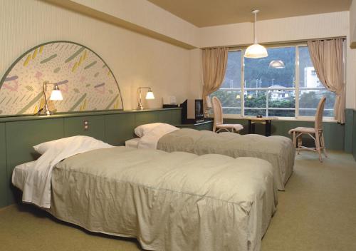 a room with four beds and a desk and a window at Tabist Kinugawa Park Cottage in Nikko
