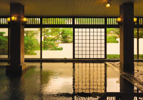 a pool of water in a building with windows at Tabist Kinugawa Park Cottage in Nikko