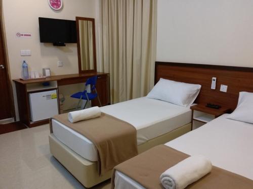 a hotel room with two beds and a tv at Hulhan'gu Lodge in Himmafushi