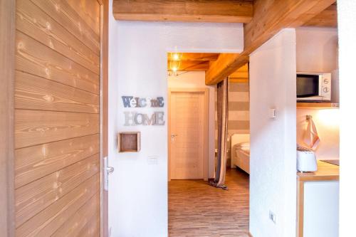 a hallway leading to a bedroom with wooden walls at Sweet Laghel Apartments in Arco