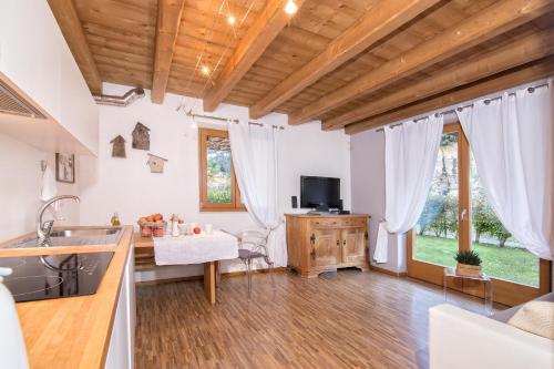 a kitchen and living room with wooden ceilings at Sweet Laghel Apartments in Arco