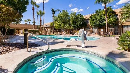 a swimming pool in a resort with palm trees at Best Western Tucson Int'l Airport Hotel & Suites in Tucson