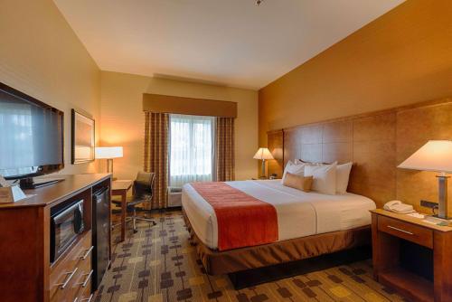 a hotel room with a bed and a flat screen tv at Best Western Plus Delta Inn & Suites in Oakley
