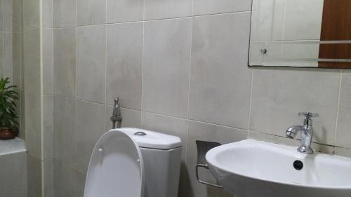 a bathroom with a toilet and a sink at Hulhan'gu Lodge in Himmafushi