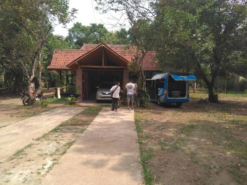 two people walking out of a house with a van at Griyo Jagalan in Borobudur