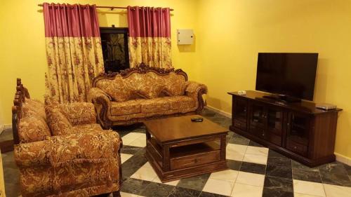 a living room with a couch and a flat screen tv at Golden Hill 34 in Cameron Highlands