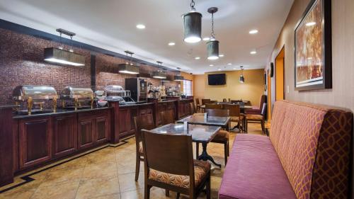 a restaurant with a bar and tables and chairs at Best Western J. C. Inn in Junction City