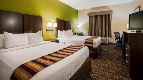 Habitación de hotel con 2 camas y TV de pantalla plana. en Best Western Rayne Inn, en Rayne