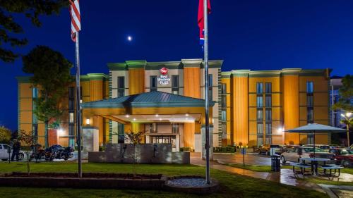 a yellow building with two flags in front of it at Best Western Plus Galleria Inn & Suites in Memphis