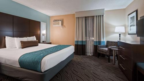 a hotel room with a bed and a chair at Best Western Plus Galleria Inn & Suites in Memphis