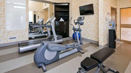 a gym with several tread machines and a television at Best Western Sunrise Inn & Suites in Stony Plain