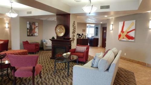 a living room with a couch and a fireplace at Best Western Plus Rose City Suites in Welland