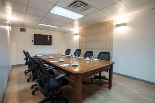 a conference room with a large wooden table and chairs at Hôtel Albert par G5 in Rouyn