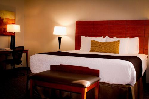 a bedroom with a large bed with a red headboard at Best Western Plus Arrowhead Hotel in Colton