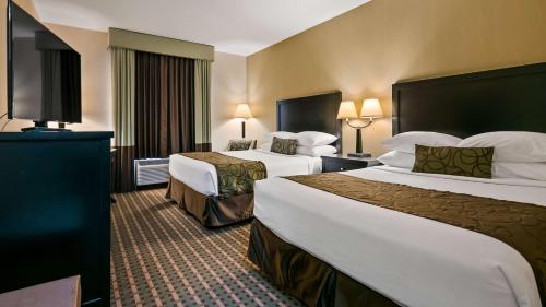 um quarto de hotel com duas camas e uma televisão de ecrã plano em Best Western Pacific Inn em Vernon