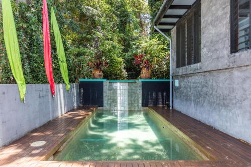 a swimming pool in the middle of a house at CELADON Holiday House in Palm Cove
