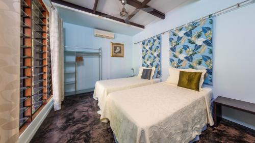two beds in a room with blue walls at CELADON Holiday House in Palm Cove