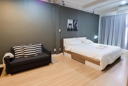 una camera da letto con un letto e una sedia nera di Pann Residence a Bangkok