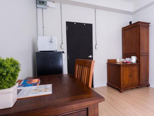 una stanza con un tavolo di legno e un frigorifero nero di Pann Residence a Bangkok