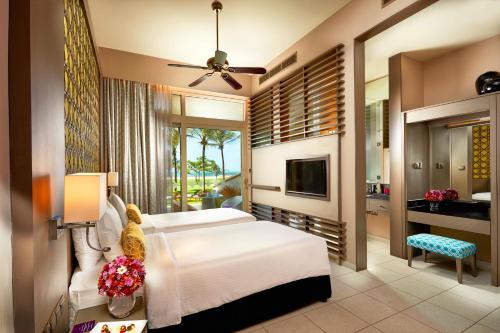 a bedroom with a white bed and a television at Sentido Heritance Negombo in Negombo