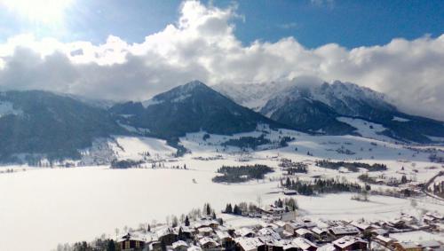 a village in the snow with mountains in the background at Mountain Inn Chalets & Apartments in Walchsee