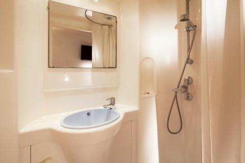 a bathroom with a sink and a mirror at Premiere Classe Les Ulis - Courtaboeuf in Les Ulis