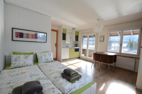 Un dormitorio con una cama y una mesa. en The Boat House en Goldswil