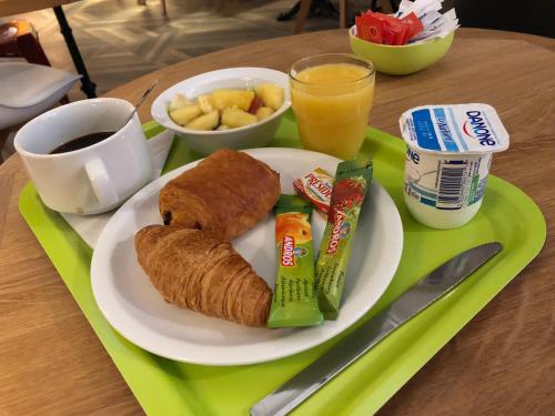 a plate of food with a breakfast of pastries and juice at Ibis Budget Annecy sud-Poisy in Poisy