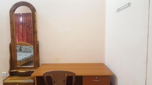 a room with a wooden table and a mirror at Tulip Guest Inn in Point Pedro