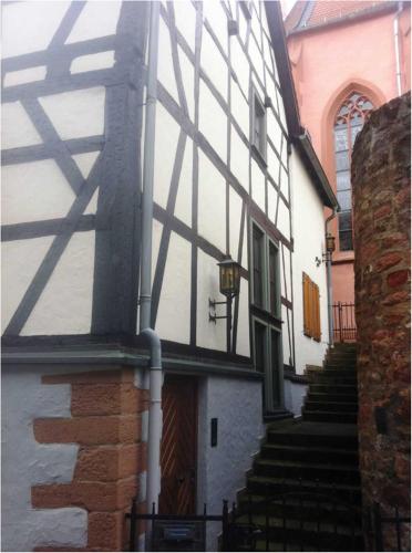 a white building with a gate and stairs leading to it at Ferienhaus Gloecknerhaus in Michelstadt