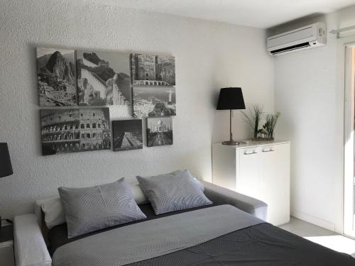 um quarto com uma cama com fotografias na parede em Les Hameaux em Bandol