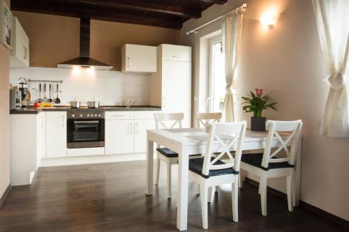 a white kitchen with a white table and chairs at Ferienhaus Kaiserhof in Markkleeberg